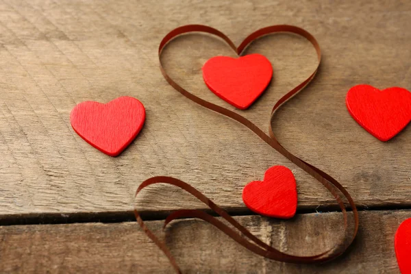 Magnetické pásky ve tvaru srdce na dřevěné pozadí — Stock fotografie