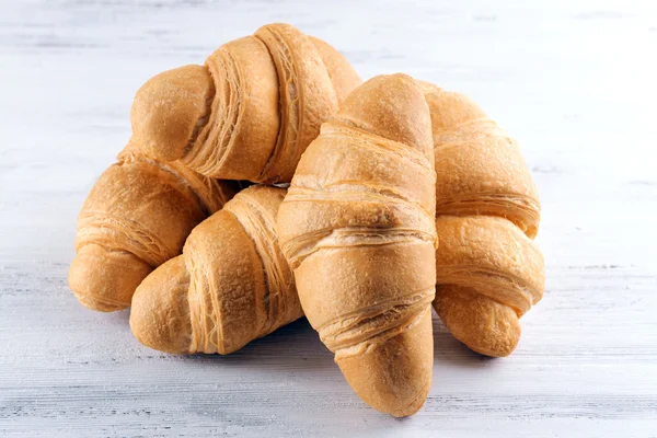 Delicious croissants on table on light background — Stock Photo, Image