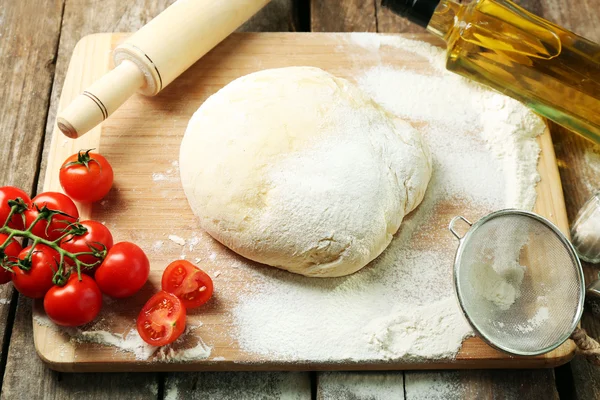 Dough on cutting board with cherry and oil on table close up — Stock Photo, Image