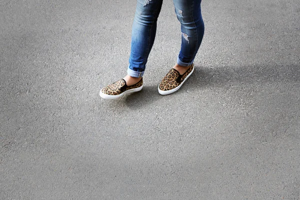 Female feet over gray asphalt background — Stock Photo, Image