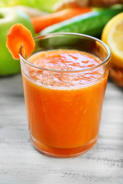 Copo de suco fresco, frutas e legumes na mesa de madeira, no fundo brilhante — Fotografia de Stock