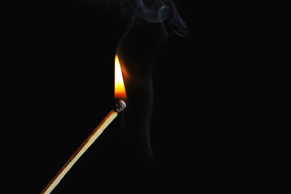 Fósforo ardiente con humo sobre fondo oscuro — Foto de Stock