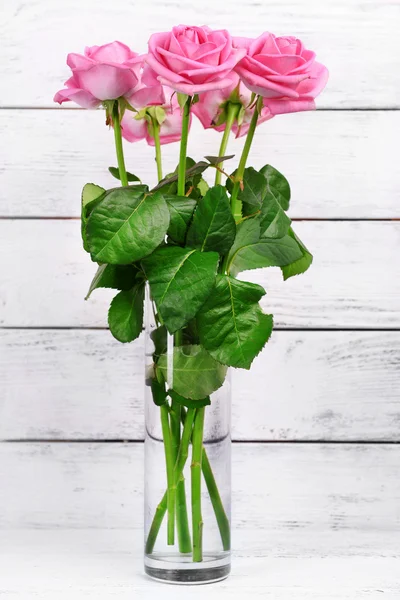 Krásné růžové růže na dřevěném pozadí — Stock fotografie
