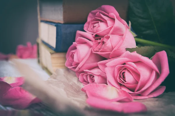 Beautiful pink roses with stack of books, closeup — Stock Photo, Image