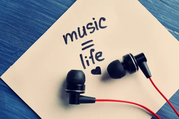 Kopfhörer mit Textmusik - Leben auf Sticker auf Holztisch, Nahaufnahme — Stockfoto