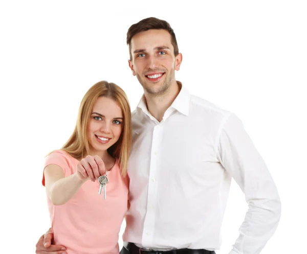 Casal jovem atraente mostrando nova chave da casa, isolado em branco — Fotografia de Stock