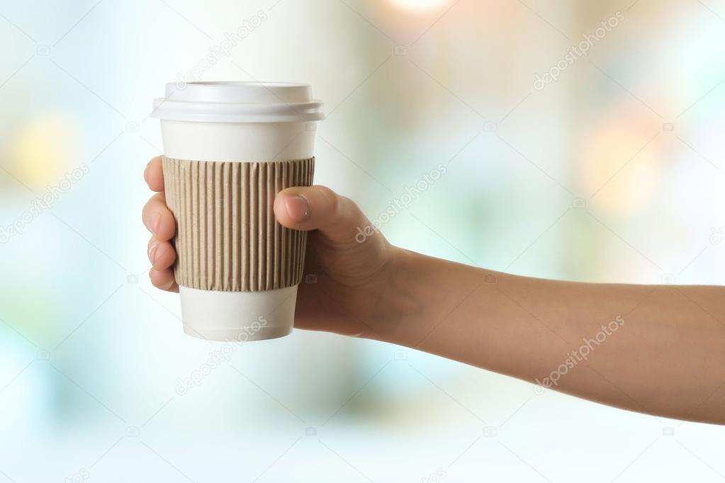 Hand holding paper cup of coffee on bright background — Stock Photo ...