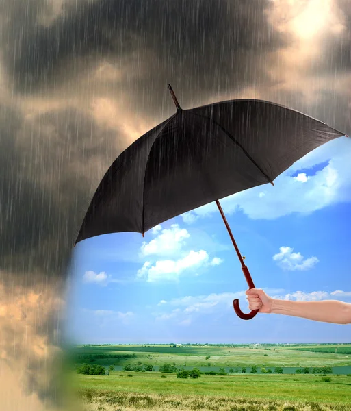 Regenschirm und dunkle Regenwolken — Stockfoto