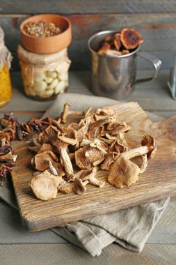 Ahşap arka plan üzerinde kesme tahtası üzerinde kurutulmuş mantar