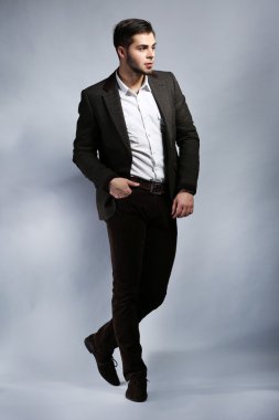 gri arka plan üzerinde takım elbiseli şık adam
