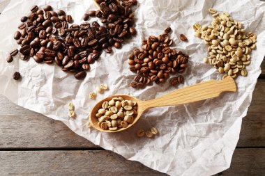 Ahşap masa, closeup üzerinde buruşuk parşömen üzerine kahve çekirdekleri