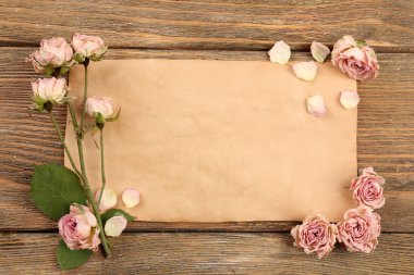 Ahşap masa, üstten görünüm üzerinde kağıt üzerine kurutulmuş güller