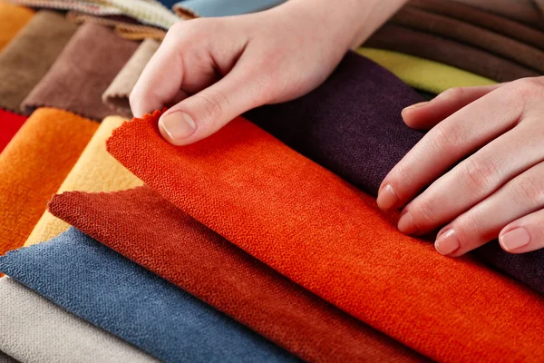 Mulher escolhe pedaços de tecido colorido na mesa de perto — Fotografia de Stock