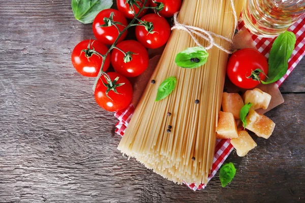 Pasta with cherry tomatoes and other ingredients on wooden table background — Stock Photo, Image