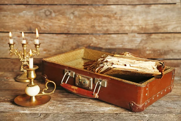 Старый деревянный чемодан со старыми книгами на деревянном фоне — стоковое фото