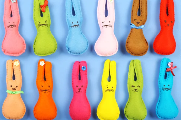 Lapins de Pâques faits à la main sur la table de couleur, vue du dessus — Photo