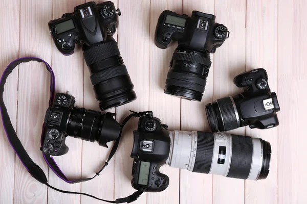 Modern cameras on wooden table, top view — Stock Photo, Image