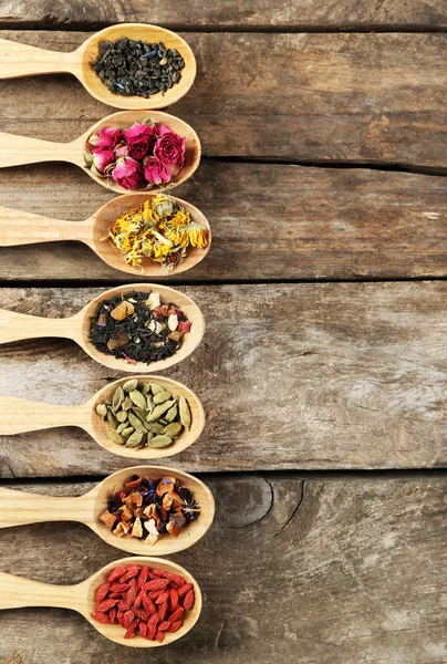 Samling av te och naturliga tillsatser i träslevar, på gamla träbord — Stockfoto