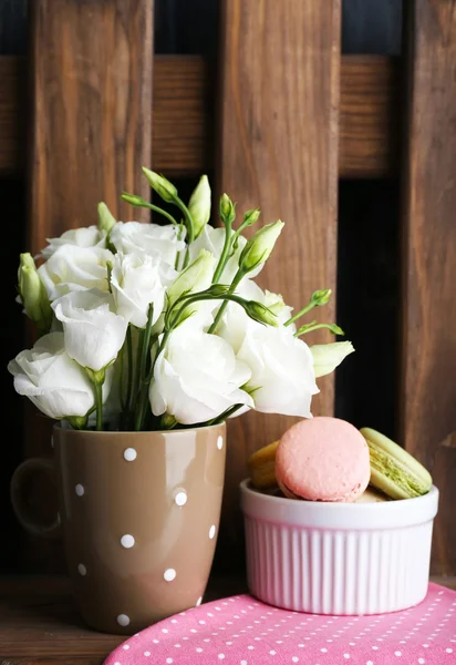 Heerlijke macaroon met mooie bloemen op houten achtergrond — Stockfoto