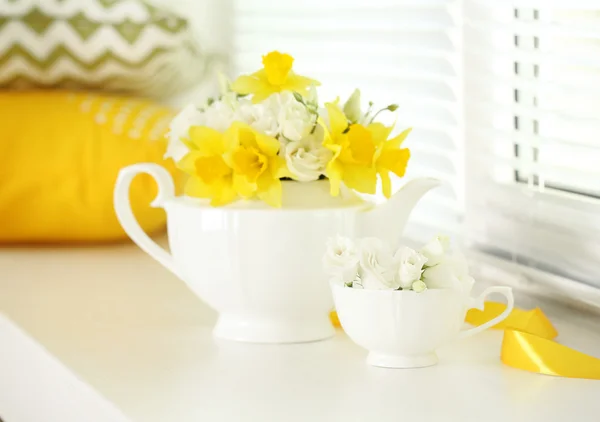 Bellissimo bouquet di narcisi gialli e rose in teiera sul davanzale della finestra — Foto Stock