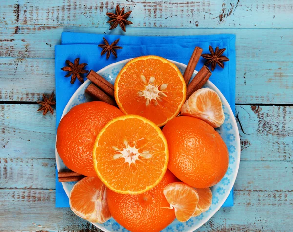Oranje tangerines en kaneelstokjes op blauwe houten tafelblad bekijken — Stockfoto