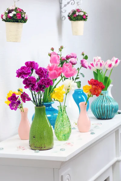Hermosa composición con diferentes flores en jarrones sobre fondo de pared — Foto de Stock