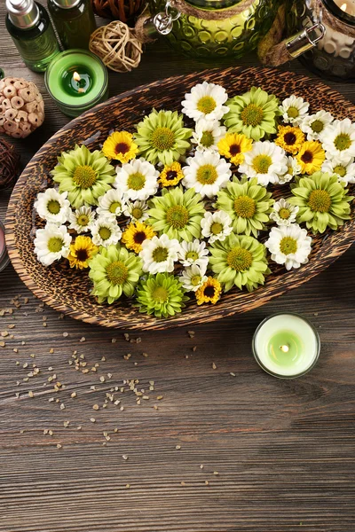 Velas com flores na placa na mesa de perto — Fotografia de Stock