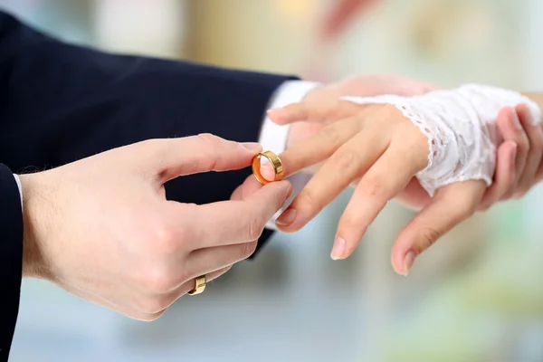 Mulher e homem segurando anéis de casamento, close-up, no fundo brilhante — Fotografia de Stock