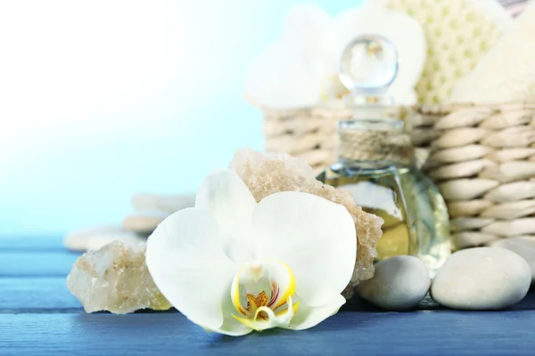 Stilleven met prachtige bloeiende orchidee bloem, spabehandeling op houten tafel, op lichte achtergrond — Stockfoto