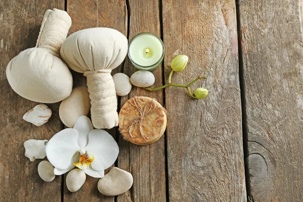 Still life with beautiful blooming orchid flower, spa treatment and pebbles, on wooden background — Stock Photo, Image