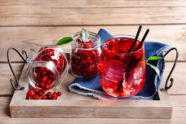 Compote with red currant on tray on wooden background — Stock Photo, Image