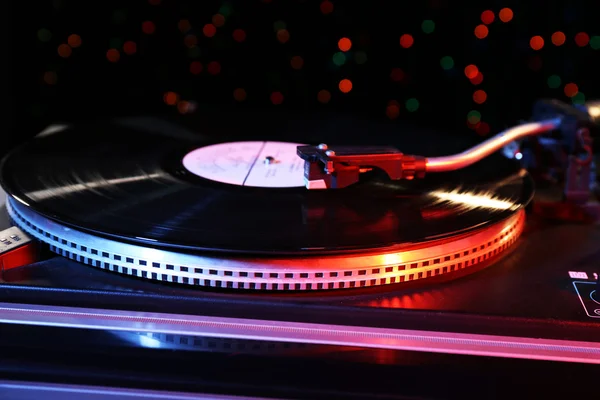 Grammofono con un disco in vinile su sfondo sfocato colorato — Foto Stock