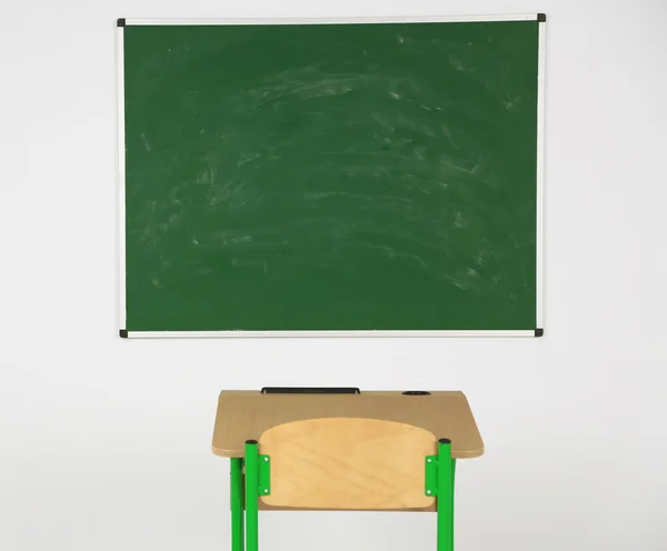 Tabule a dřevěný stůl s židlí ve třídě — Stock fotografie