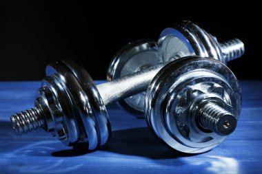 Koyu arka plan üzerinde renkli tahta üzerinde halter