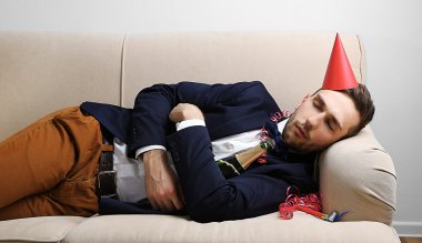 Genç adam eğlenceli kapattıktan sonra kanepede