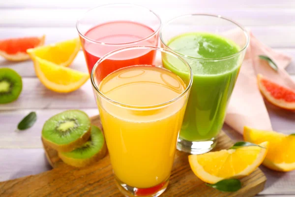 Jugos frescos con frutas en mesa de madera — Foto de Stock