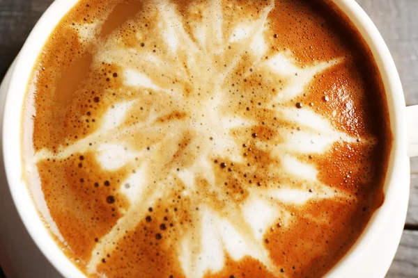 Kopp kaffe latte art på träbord, närbild — Stockfoto