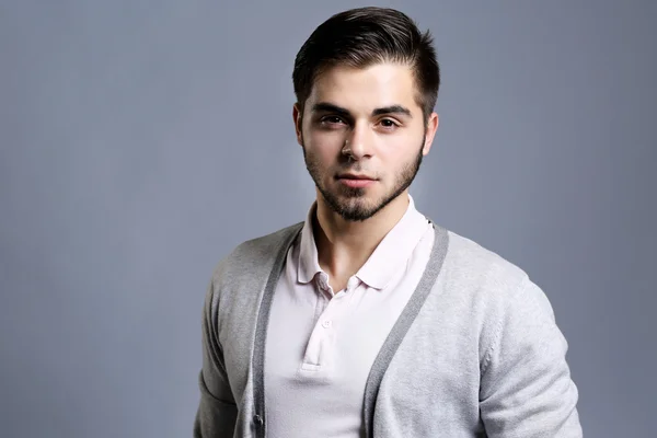 Portrait of young man on gray background — Stock Photo, Image