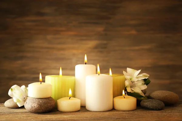 Hermosa composición con velas y piedras de spa sobre fondo de madera —  Fotos de Stock