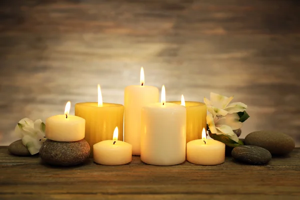 Hermosa composición con velas y piedras de spa sobre fondo de madera — Foto de Stock