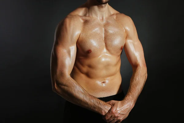 Muscle young man on dark background — Stock Photo, Image
