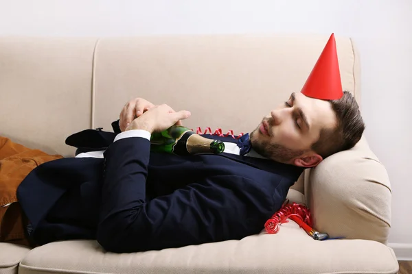 Fiatal férfi a kanapén után szórakoztató közelről — Stock Fotó
