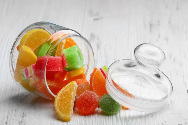 Caramelle colorate in vaso su fondo di legno — Foto Stock