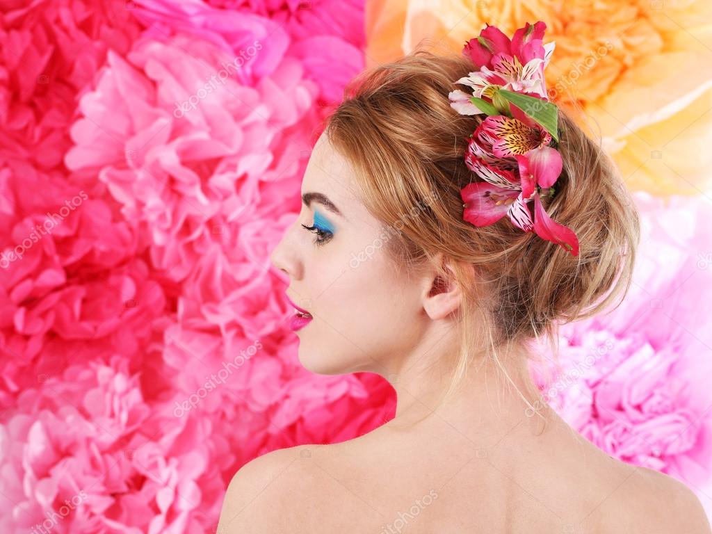花在头发上明亮的粉红色背景的年轻女子的画像 图库照片 C Belchonock