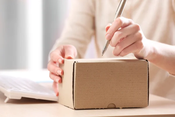 Vrouw tekenen perceel in post office — Stockfoto