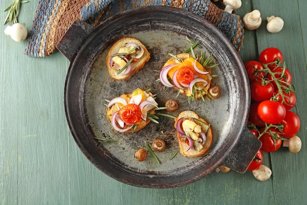 Tasty sandwiches on old pan, on wooden table — Stock Photo, Image