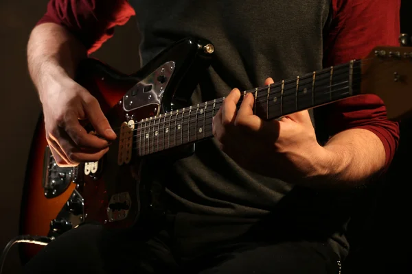 Ung man spelar på elgitarr på nära håll — Stockfoto