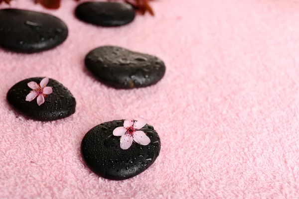 Спа-камни и весенние цветы на фоне полотенец — стоковое фото
