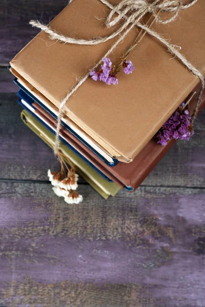 Montón de libros con flores secas sobre fondo de madera — Foto de Stock