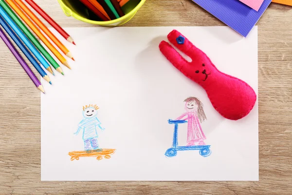 Kids drawing on white sheet of paper on wooden table, top view — Stock Photo, Image